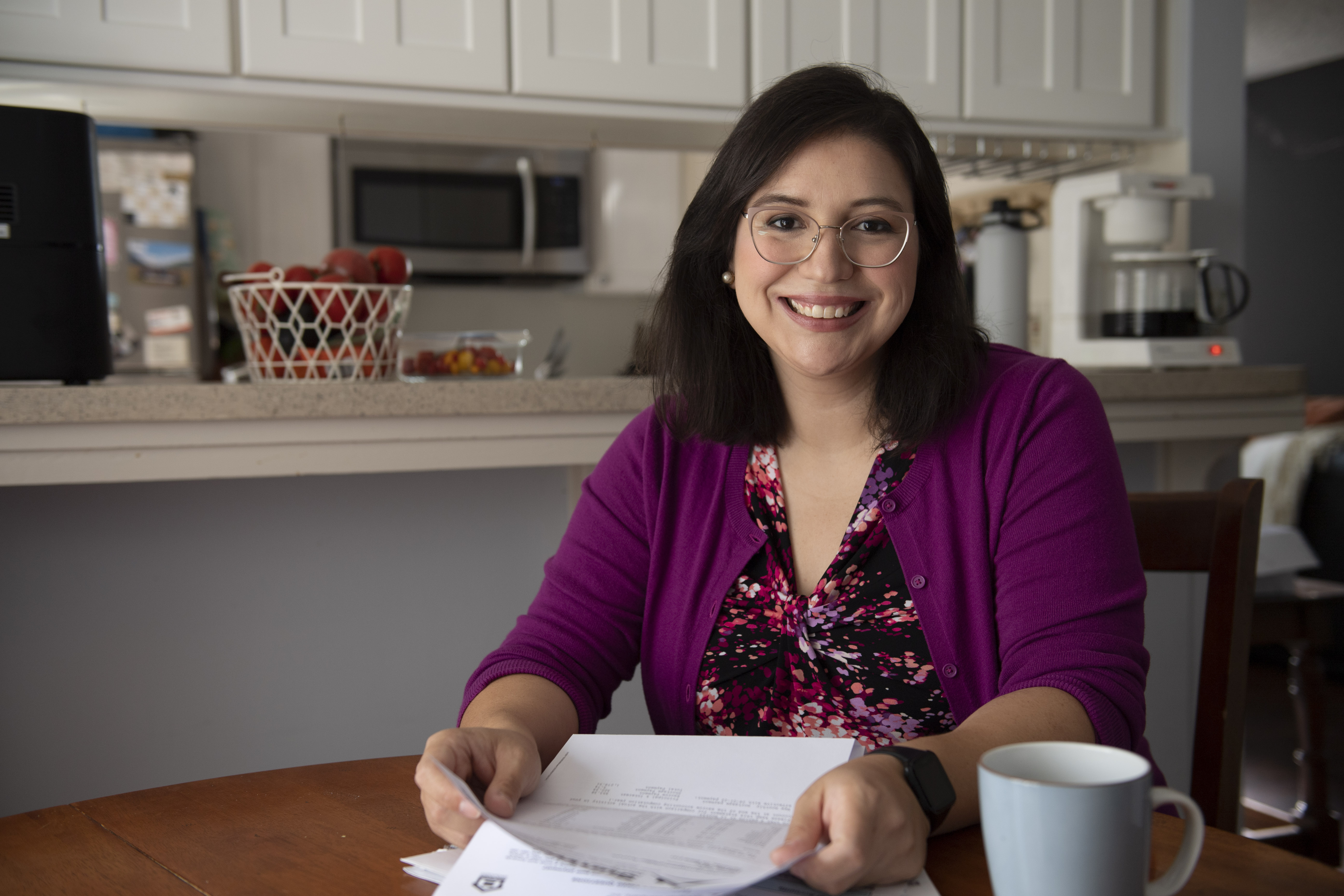 Paula Villescaz reviewing documents at her kitchen table